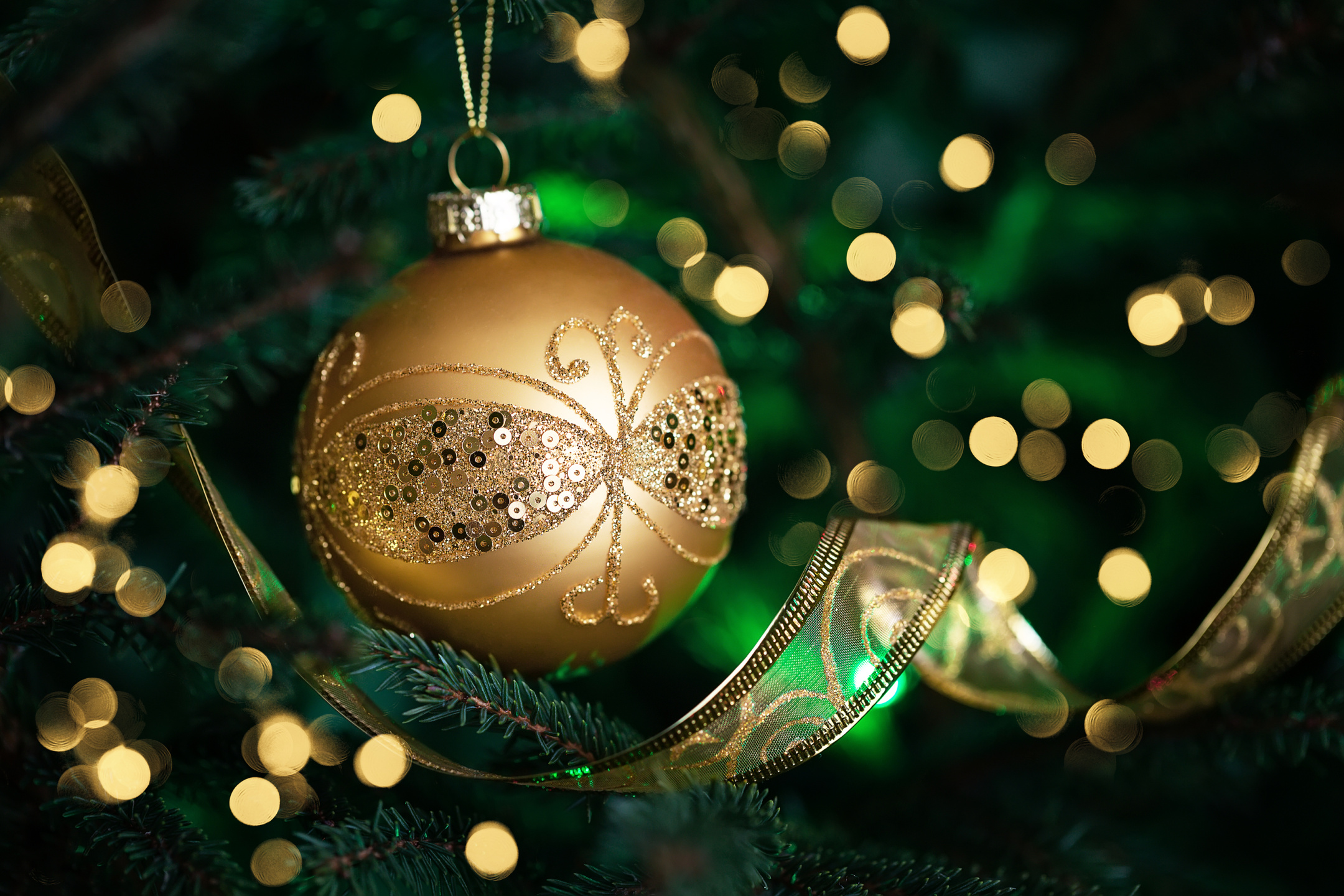 Close Up Of Golden Ball On Christmas Tree. Christmas Fir Tree Wi